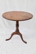 Georgian mahogany tilt-top table with circular top supported on a turned column and tripod base, top