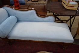 VICTORIAN MAHOGANY FRAMED CHAISE LONGUE WITH SHAPED BACK, TURNED LEGS AND UPHOLSTERED IN LIGHT