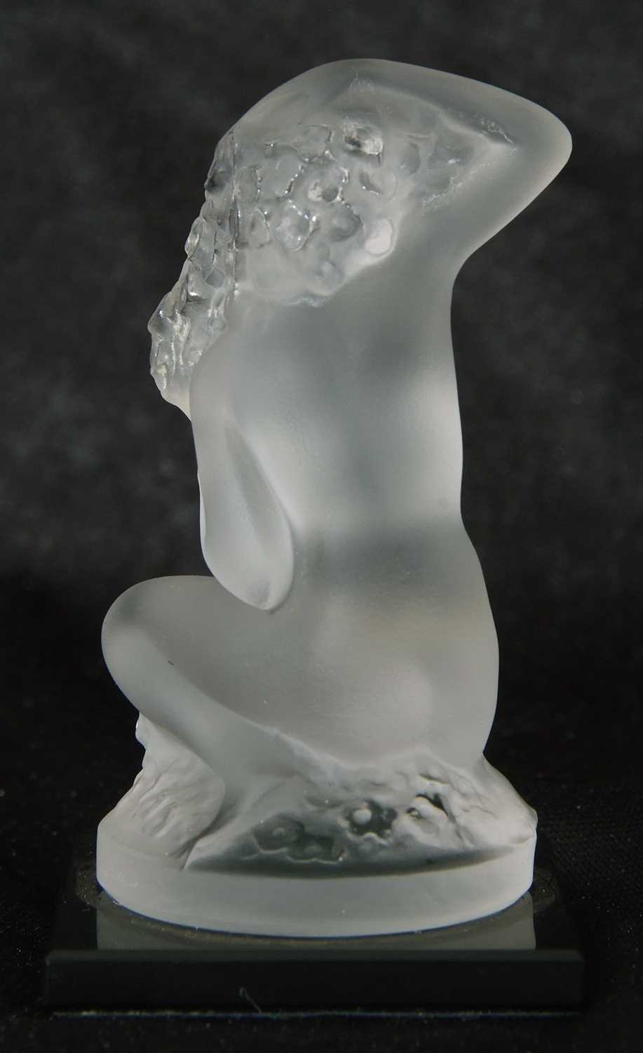 Small Lalique model of a nude lady crouching on circular base, mounted on a black glass - Image 3 of 4