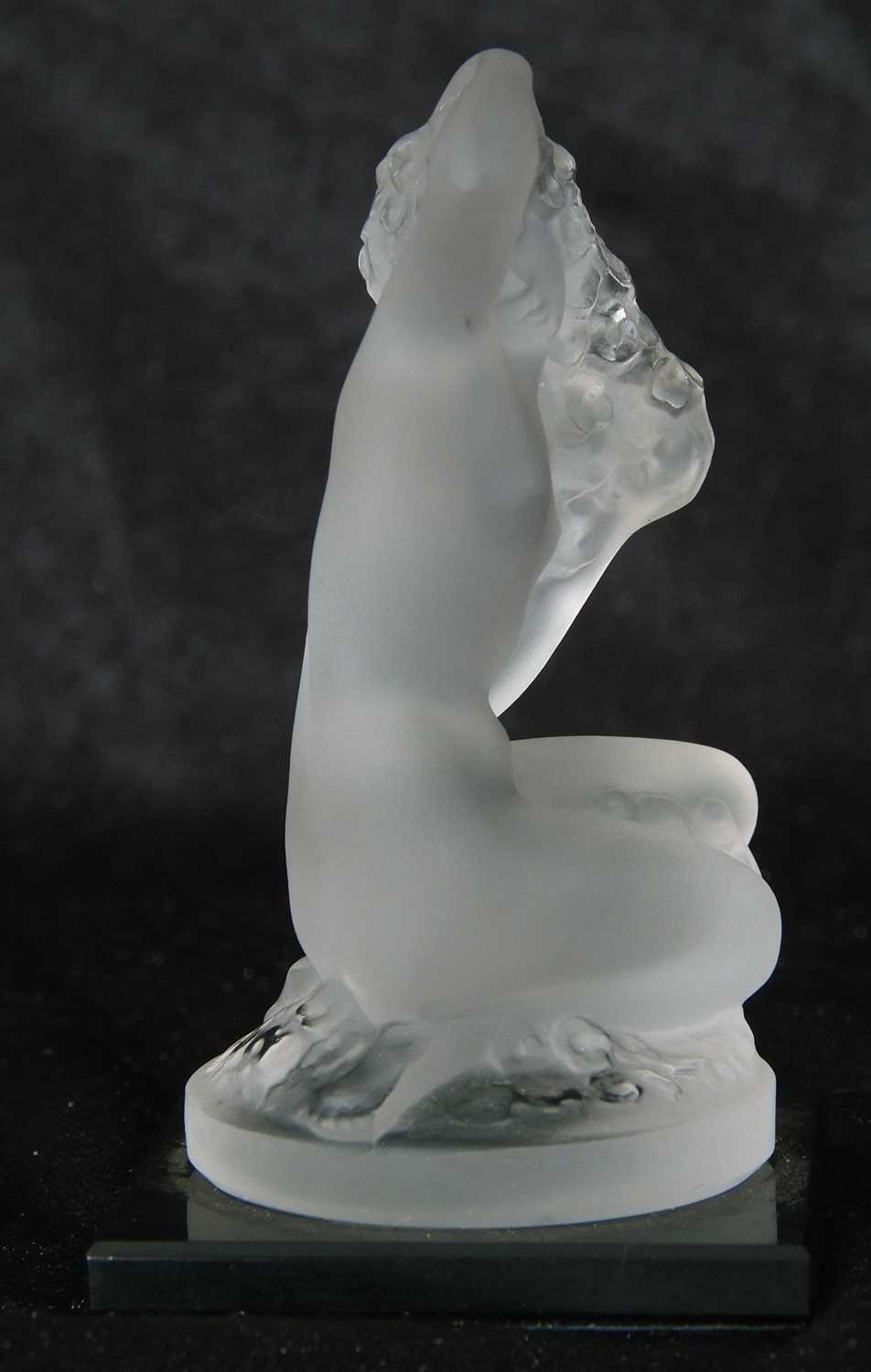 Small Lalique model of a nude lady crouching on circular base, mounted on a black glass - Image 2 of 4