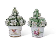 Two Derby porcelain flower pots with ceramic flowers above, the bases also with floral decoration (