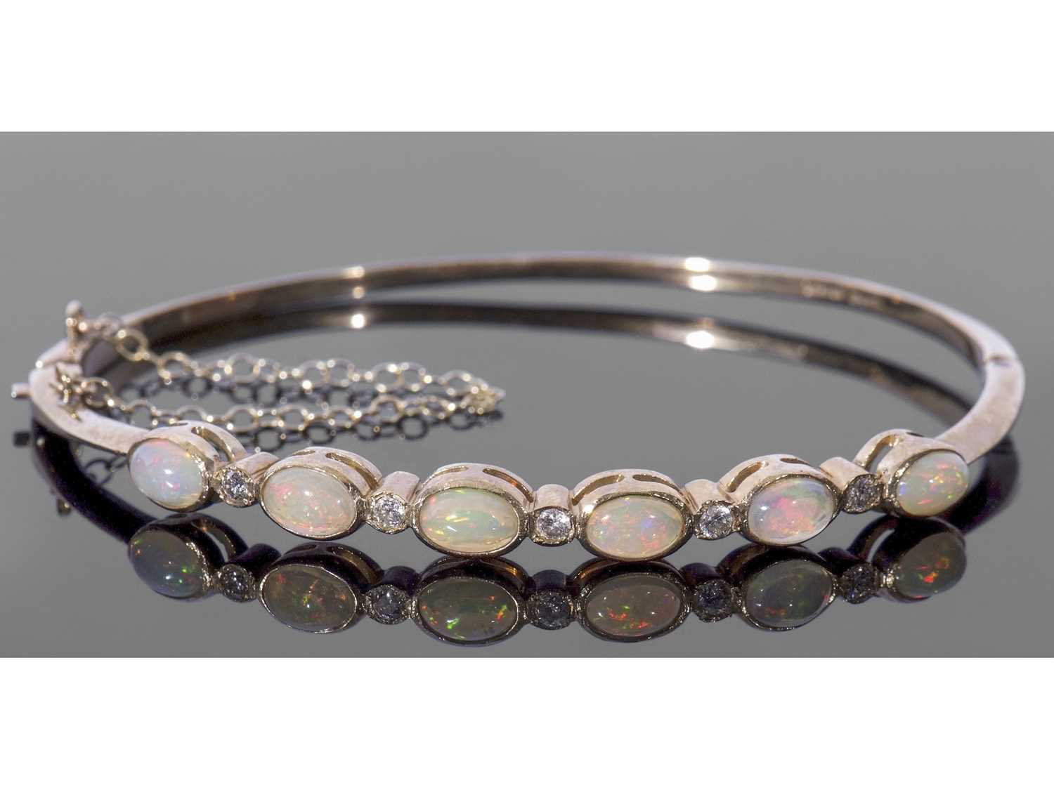 9ct gold opal and diamond set hinged bracelet, the top section with six oval cut cabochon opals,