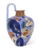 Bursley ware ewer with a design of flowers on blue ground by Frederick Rhead, 22cm high