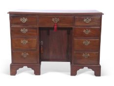 George III mahogany kneehole desk, the body with nine drawers and a central door fitted with brass