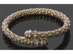 Italian coil cross over design bracelet, each terminal cap with a band of small diamonds, stamped