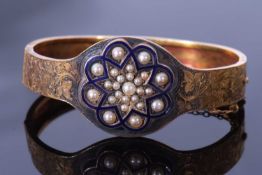 Early 20th century enamel and seed pearl hinged bracelet, the top section with chased and engraved