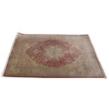 20th century Persian silk floor rug decorated with a large central red medallion surrounded by a