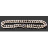 Double row cultured pearl necklace with a large gold, sapphire and diamond clasp, two rows of