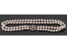 Double row cultured pearl necklace with a large gold, sapphire and diamond clasp, two rows of