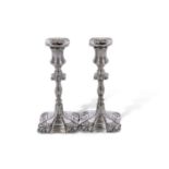 Pair of Edwardian silver encased candlesticks in early 18th century style, having loaded shaped