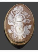 Carved cameo brooch of oval form depicting a floral spray, framed in a yellow metal mount (tested