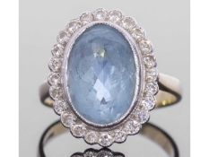 Large aquamarine and diamond cluster ring, the oval faceted aquamarine 12 x 8 x 6.6mm approx, framed