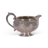 Victorian silver cream jug of slightly compressed circular form with embossed decoration, leaf