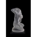 Small Lalique model of a nude lady crouching on circular base, mounted on a black glass