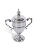 George V silver trophy cup of standard form with raised body band, leaf capped double C scrolled