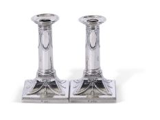 Pair of Victorian silver encased dressing table candlesticks, having beaded square loaded bases