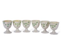 Set of six Belleek egg cups decorated with shamrocks, one egg cup with first period black mark to