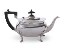 Early 20th century silver tea pot of slightly compressed oval form having card cut rim, ebonised