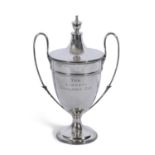 George V silver trophy cup and lid with leaf capped looped handles, urn finial to the push-on lid,