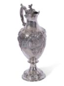Victorian silver claret jug of tapering baluster form to a shaped circular foot, rococo style