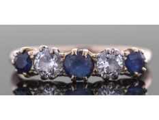 Sapphire and diamond five stone ring, alternate set with three round faceted sapphires and two round