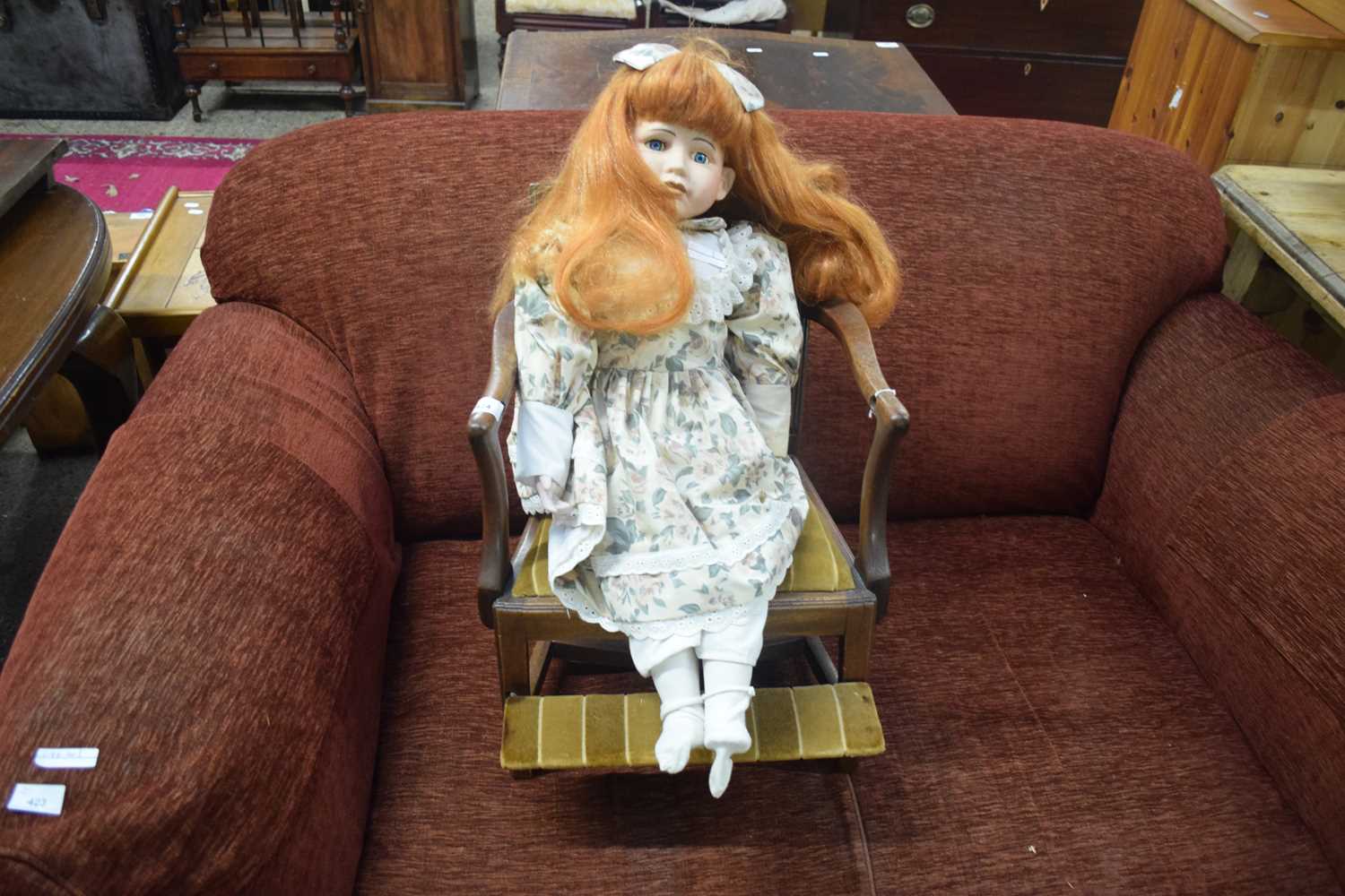 MAHOGANY FRAMED CHILDS CHAIR CONTAINING A PORCELAIN HEADED DOLL