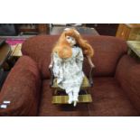 MAHOGANY FRAMED CHILDS CHAIR CONTAINING A PORCELAIN HEADED DOLL