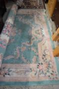 20TH CENTURY CHINESE WASHED WOOL FLOOR RUG DECORATED WITH FLOWERS ON A PRINCIPALLY GREEN BACKGROUND,