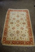 SMALL WOOL FLOOR RUG DECORATED WITH FLORAL DETAIL ON A PALE BACKGROUND