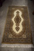 SMALL WOOL FLOOR RUG DECORATED WITH GEOMETRIC AND FLORAL DESIGN ON A BEIGE BACKGROUND