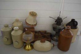 COLLECTION OF STONEWARE HOT WATER BOTTLES, FLAGONS, METAL BASED OIL LAMP, TABLE LAMP WITH WOODEN