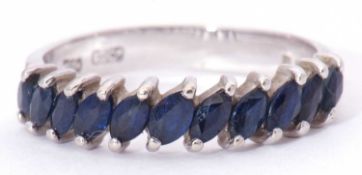 Modern 18ct white gold and sapphire half hoop ring featuring 11 faceted lozenge shaped sapphires,