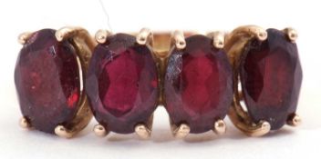 Garnet four stone ring, a row of uniform oval shaped faceted garnets, each individually four claw