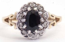 9ct gold, dark sapphire and diamond cluster ring, the oval shaped sapphire multi-claw set and raised