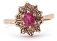 9ct gold ruby and diamond cluster ring, the centre oval ruby multi-claw set and raised above a small