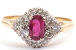 Ruby and diamond ring centring an oval cut ruby, 6.13 x 3.12 x 2.29mm, raised above a small