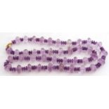 Large amethyst bead necklace, a single row of faceted and polished beads to a silver gilt clasp,