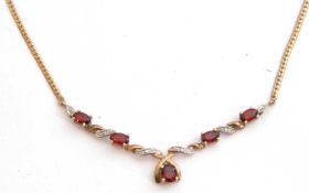 Garnet and diamond pendant/necklace set with five graduated oval cut garnets highlighted with four