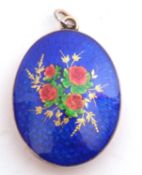 Blue, red and green enamel locket of oval form, the blue guilloche enamel decorated with a spray