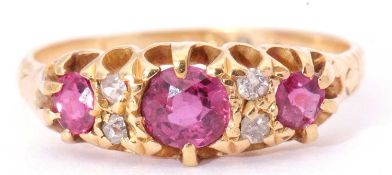 Antique ruby and diamond ring featuring three round rubies highlighted between with four small