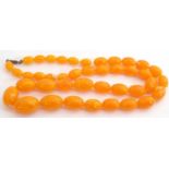 Egg yolk amber bead necklace, a single row of oval graduated beads, 15-30mm, 39cm long fastened, g/w
