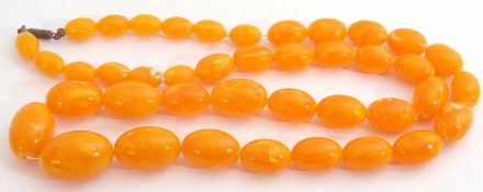 Egg yolk amber bead necklace, a single row of oval graduated beads, 15-30mm, 39cm long fastened, g/w