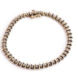 Diamond line bracelet featuring 49 small single cut diamonds set between S-bar articulated links,