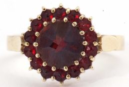 Garnet cluster ring, the large round cut faceted central garnet surrounded by 14 small garnets in