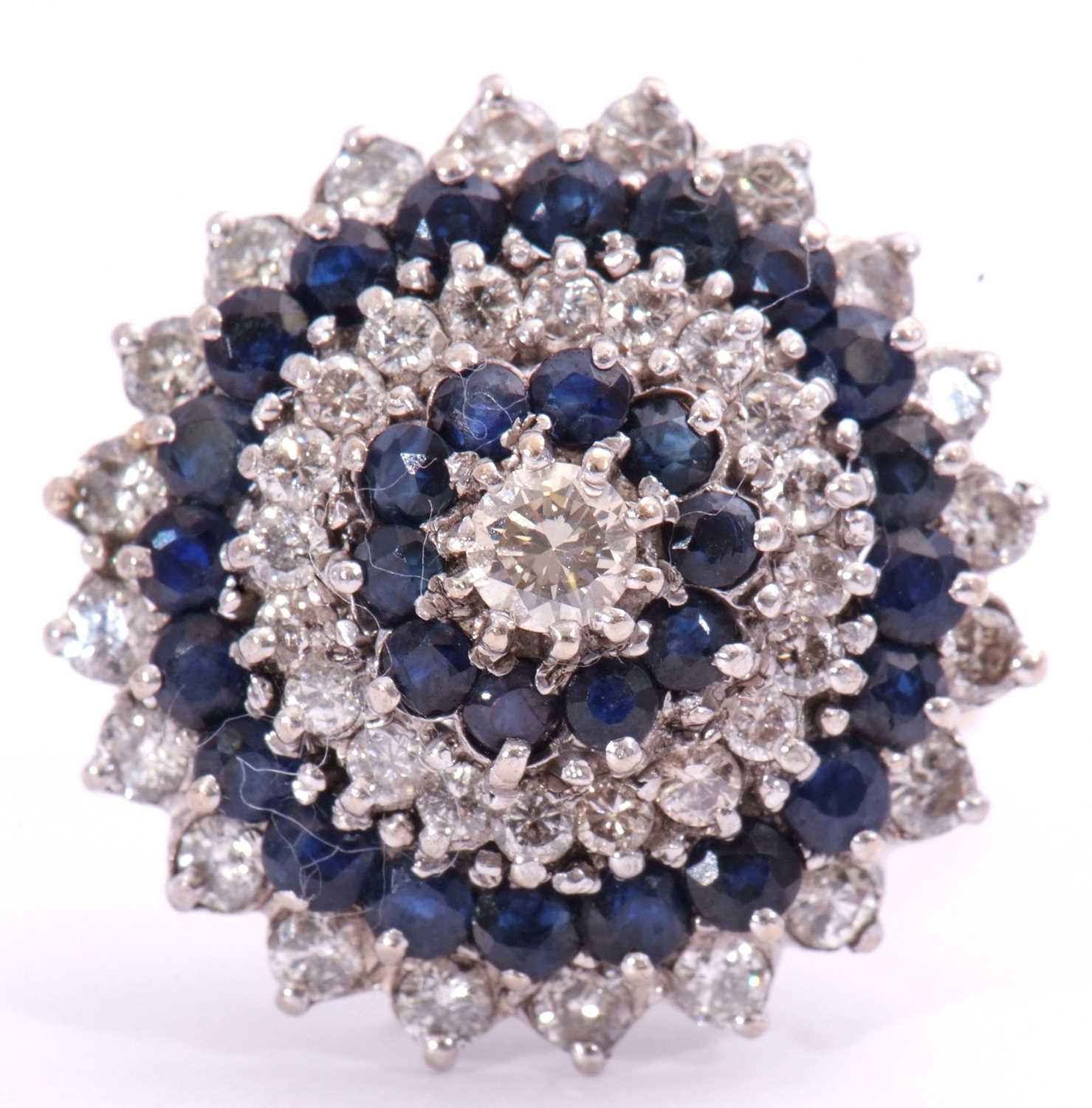 Large diamond and sapphire cocktail ring of dome design, centring a brilliant cut diamond, 0.20ct
