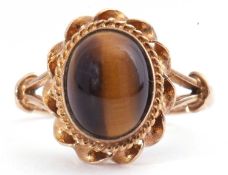 9ct gold tigers eye ring, the cabochon stone in a rope frame in cut down setting, raised between