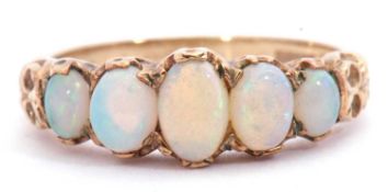 9ct gold opal five stone ring having five oval shaped cabochon opals, all in a carved gallery,