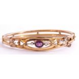Gold plated open work hinged bracelet, the top section with a purple stone and small seed pearl
