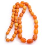 Butterscotch coloured amber bead necklace, a single row of graduated oval beads, 6-12mm diam, 23cm