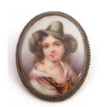 Vintage hand painted porcelain brooch of oval form depicting a young lady in a green hat, framed